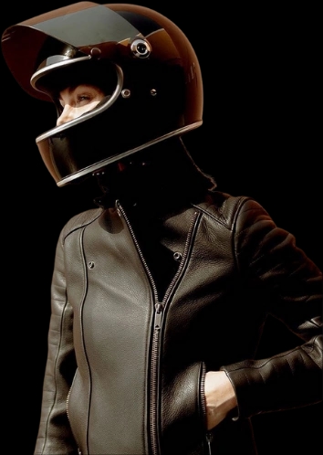 A woman rider wearing a helmet and a leather jacker